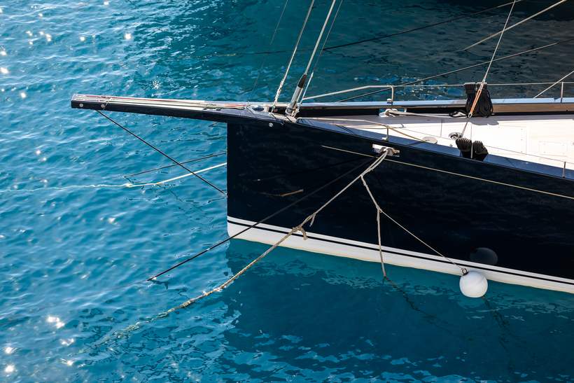 A luxury sailing yacht moored on bright turquoise water.